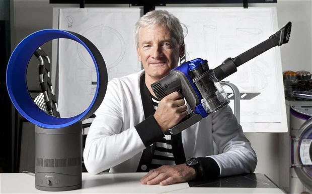 James Dyson memegang vakum Dyson dalam studio, melambangkan inovasi dan kejayaannya selepas lebih 5,000 prototaip.